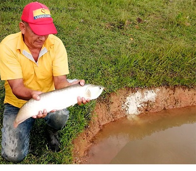 Pescador con pez en sus manos.